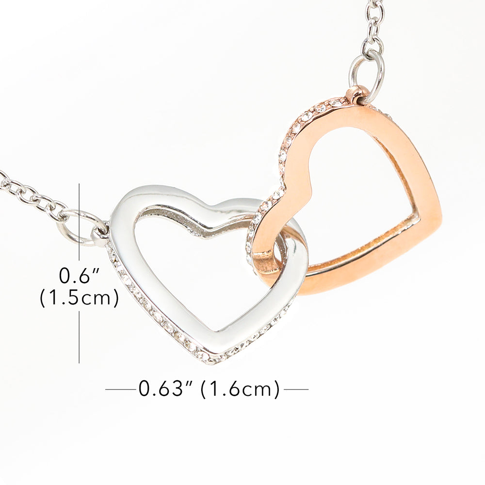 Two interlocking heart pendants on a chain with measurements indicated.